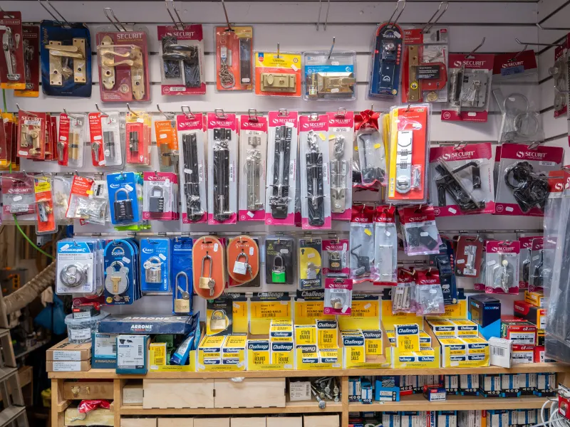A wall of locks, bolts, catches and padlocks above shelves of small fixings